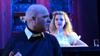 Sänger in schwarzem Hemd blickt nach hinten zu Sängerin in weißem Kleid