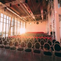 Sonne strahlt in den bestuhlten Saal 