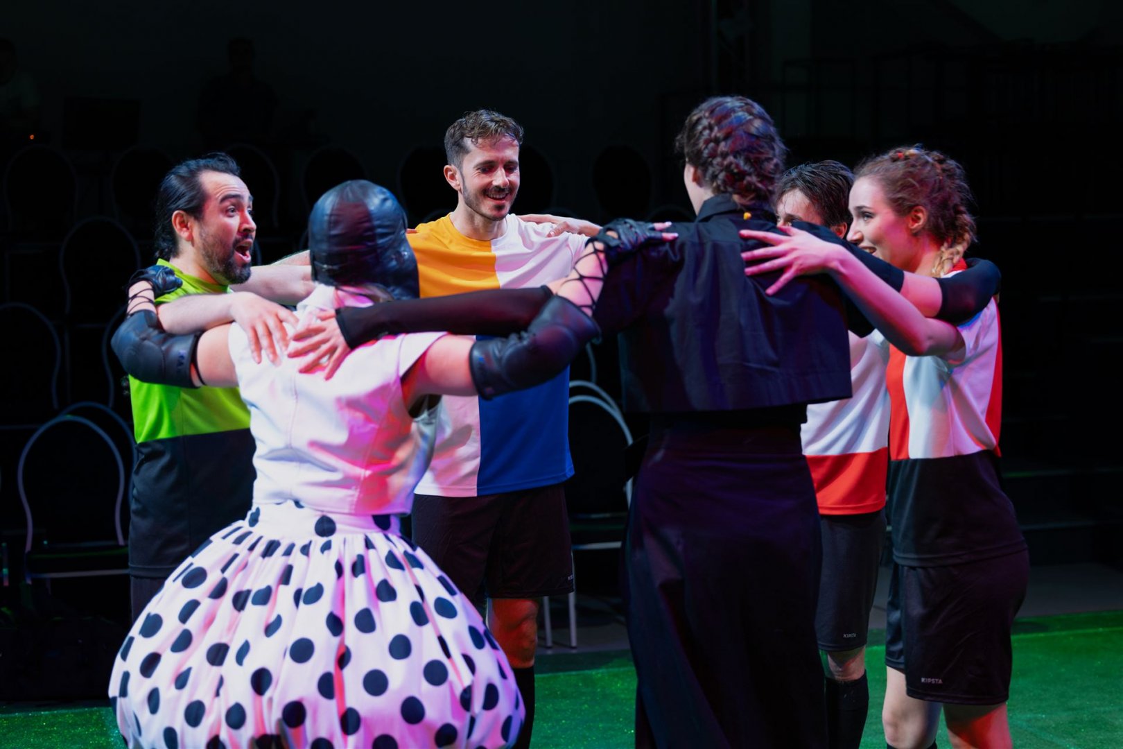 Sänger*innen der Fußballoper tragen Trikots und stehen im Kreis